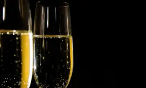 Två glas med bubblande champagne redo att utbringa en skål.