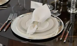Elegant dukning med flera tallrikar. Frågan "hur många tallrikar ska man ha" besvaras med en lyxig uppsättning.