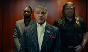 Sylvester Stallone i en serie, flankerad av två män i en hiss.