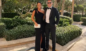 Ett par klädda för en black tie-kväll, hon i en elegant svart klänning, han i smoking.