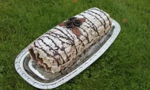 En läcker Budapestrulle med chokladrosor och pudersocker, redo att avnjutas. Ett perfekt recept för fika.