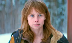 En ung kvinna med blont hår och blå ögon, klädd i en vinterjacka. Hon ser ut att vara mitt i en tanke, kanske funderar hon på varför jag for ner till bror serie.