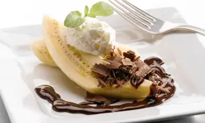 En bananhalva med vispgrädde, chokladspån och chokladsås. En klassisk banana split som ser utsökt ut.