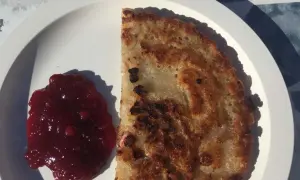 En gyllene kolbulle med lingonsylt på en vit tallrik. Perfekt för ett enkelt kolbulle recept.