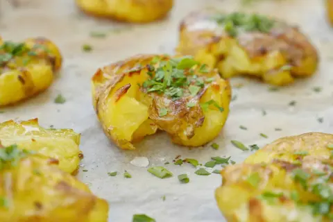Krispiga, gyllene smashed potatis toppade med färsk persilja. Perfekt tillbehör som smälter i munnen.