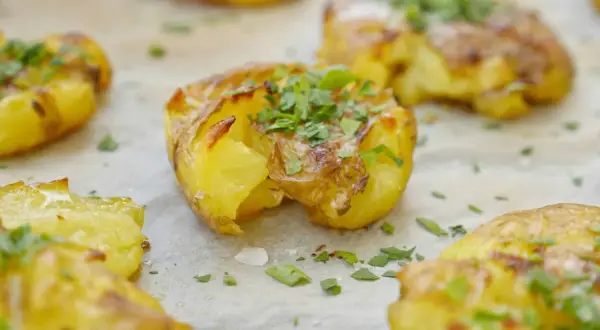 Krispiga, gyllene smashed potatis toppade med färsk persilja. Perfekt tillbehör som smälter i munnen.