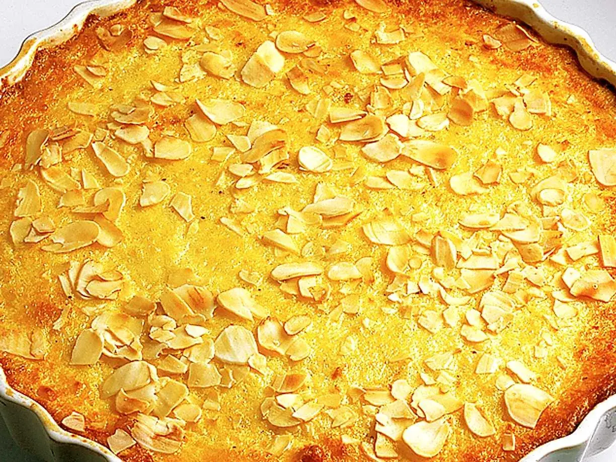 En gyllene ostkaka med mandelspån, perfekt för ett mysigt fika. Ett enkelt ostkaka recept att prova.