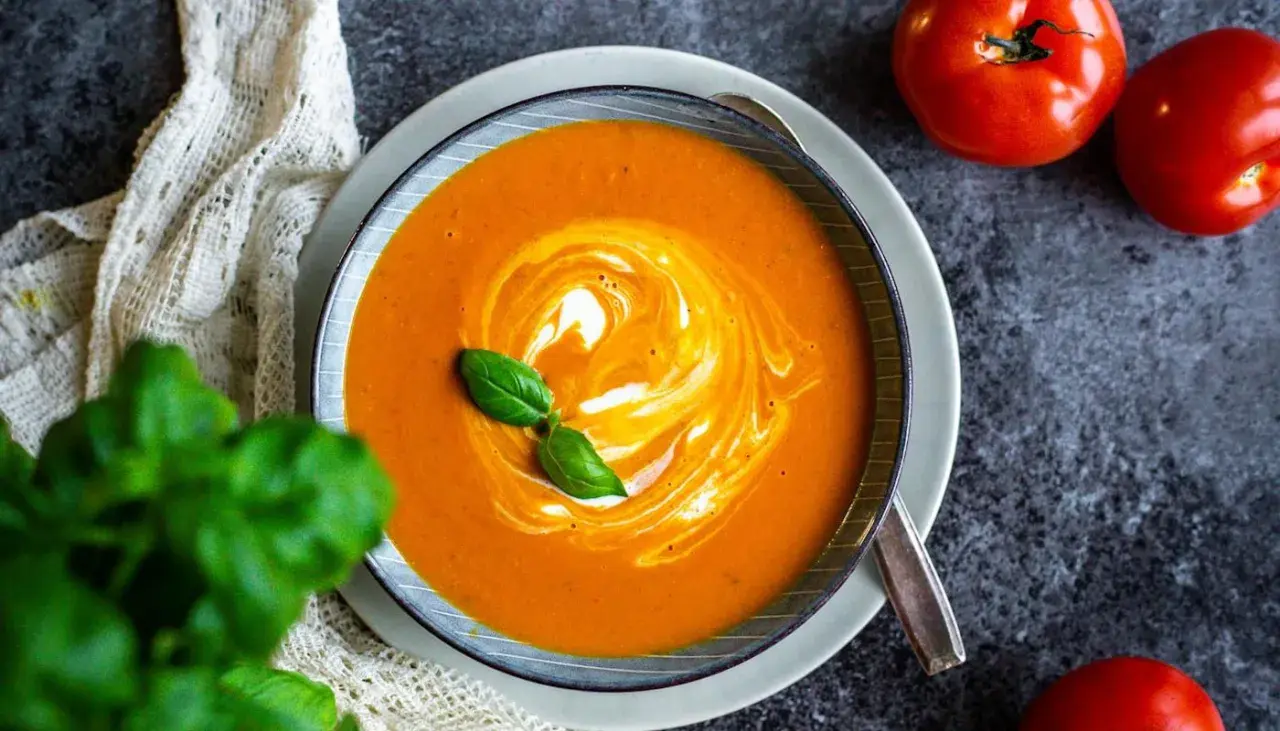 Krämig tomatsoppa med virvlar av grädde och färsk basilika. Ett perfekt tomatsoppa recept för en mysig kväll.