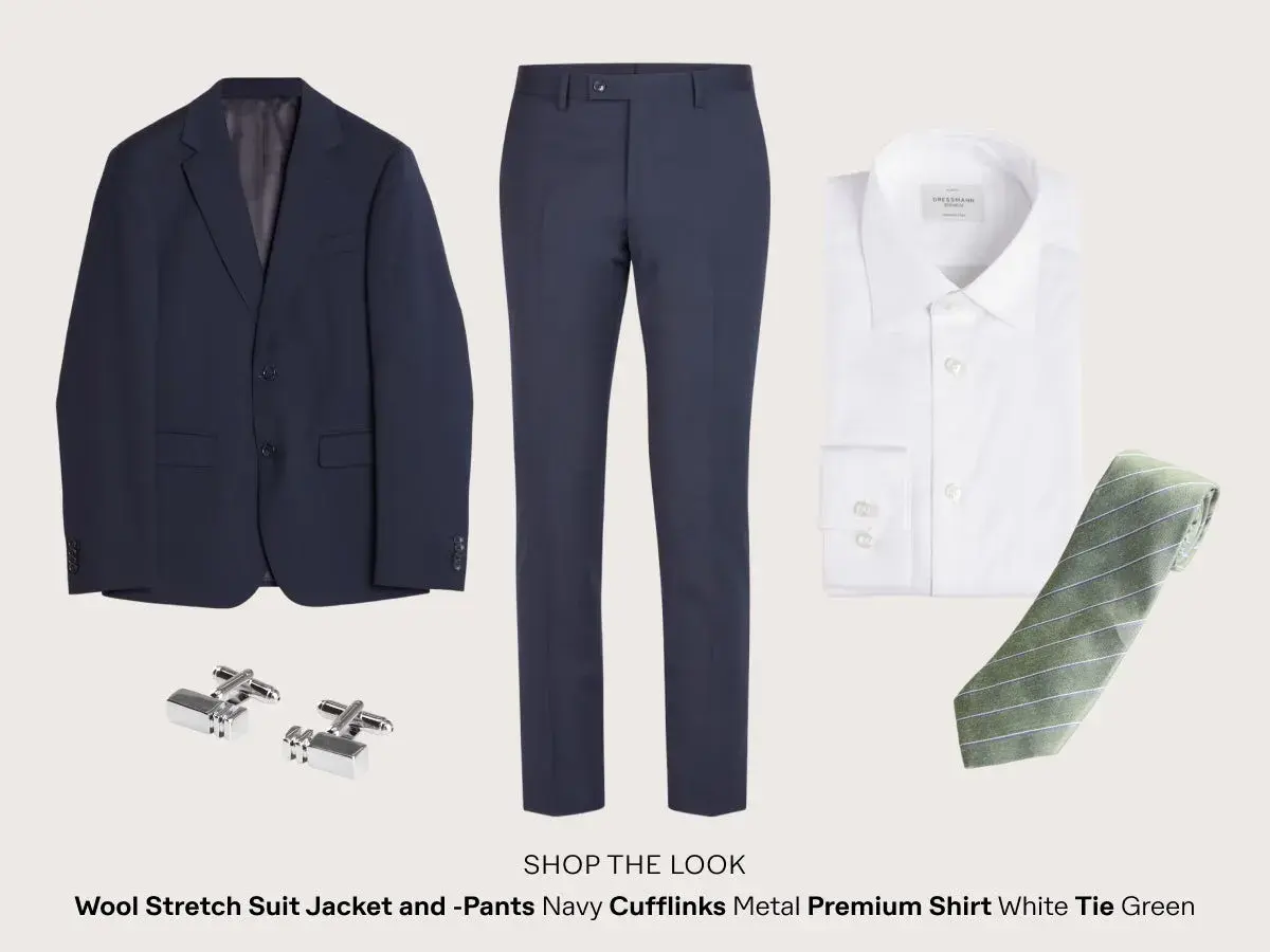 Mörkblå kostym, vit skjorta, grönrandig slips och manschettknappar. Perfekt dresscode cocktail man.