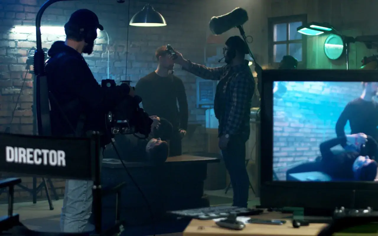Inspelningsplats för en ny dansk serie på Viaplay. Regissören övervakar scenen där en skådespelare ligger på ett bord.