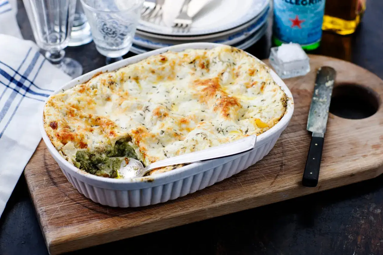 En gyllene, bubblande vegetarisk lasagne i en vit ugnsform, redo att serveras.