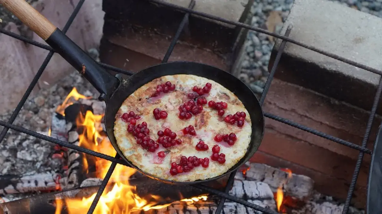 Kolbulle recept: Pannkaka med lingon steks över öppen eld i en gjutjärnspanna.