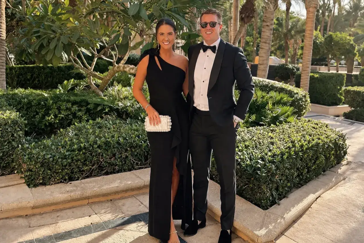 Ett par i elegant svart klädsel, redo för en kväll med black tie tema. Mannen bär smoking, kvinnan en lång svart klänning.