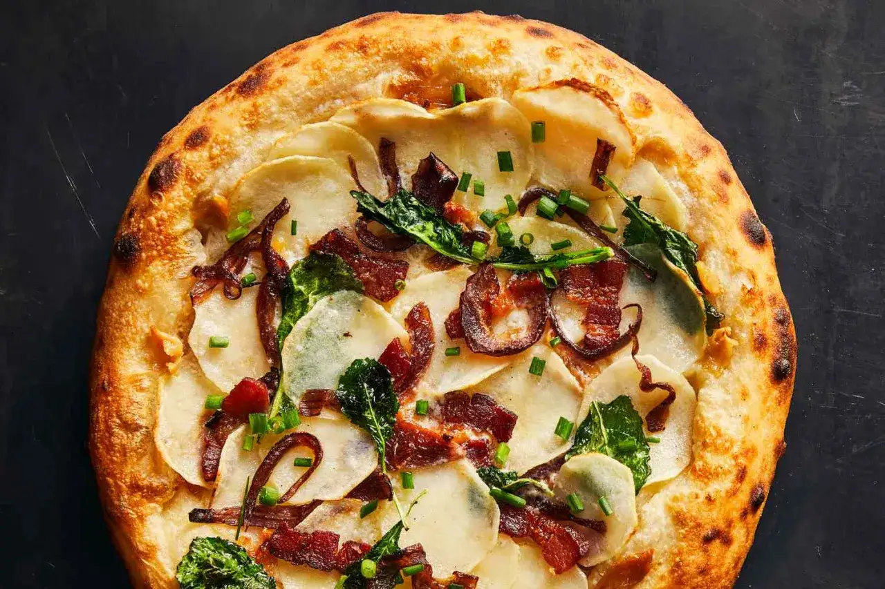 En utsökt pinsa bianco med tunna potatisskivor, krispigt bacon, karamelliserad lök och färska örter.
