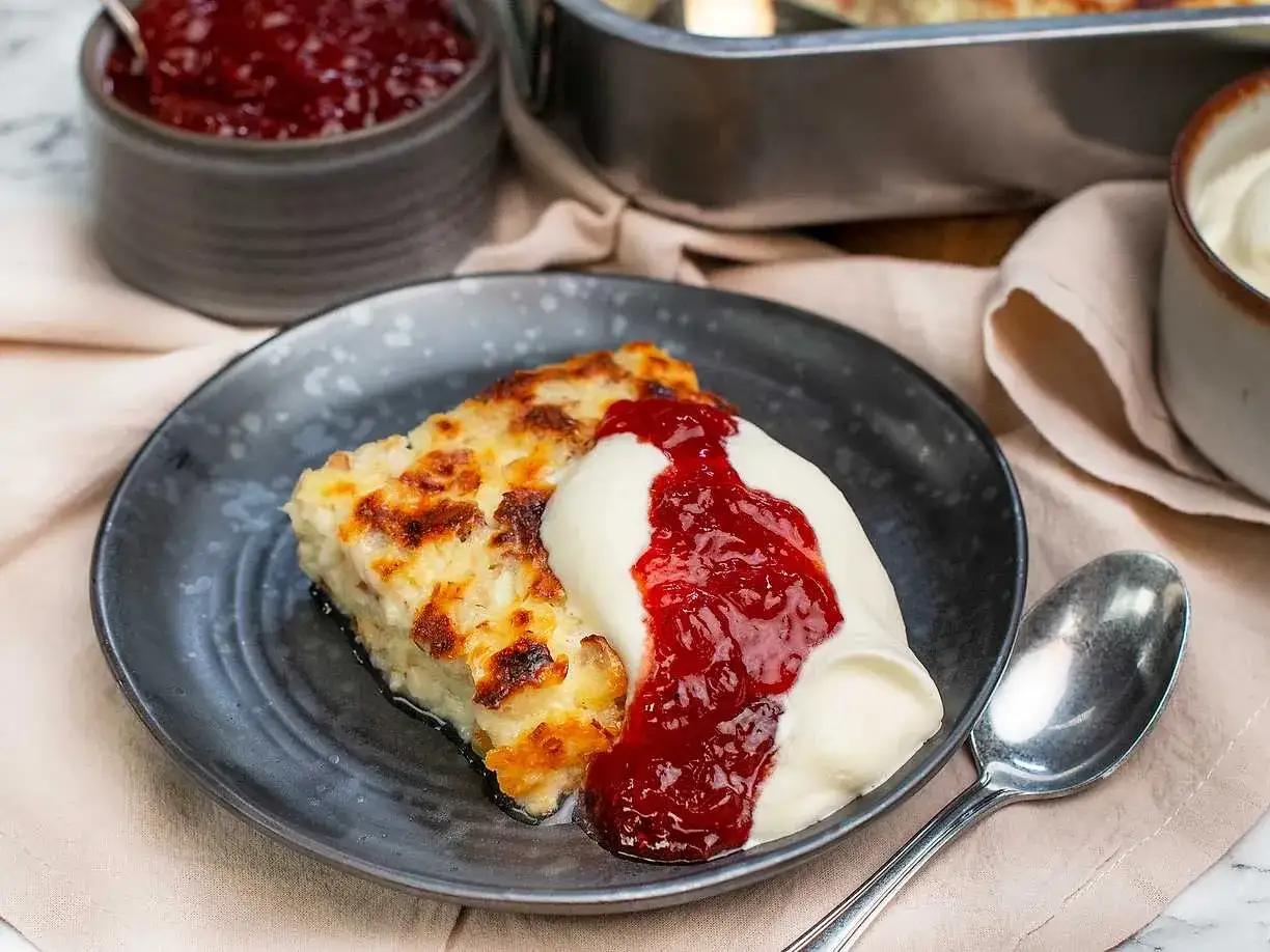 En bit gyllene ostkaka med vispad grädde och rårörda lingon. Ett perfekt ostkaka recept för alla tillfällen.