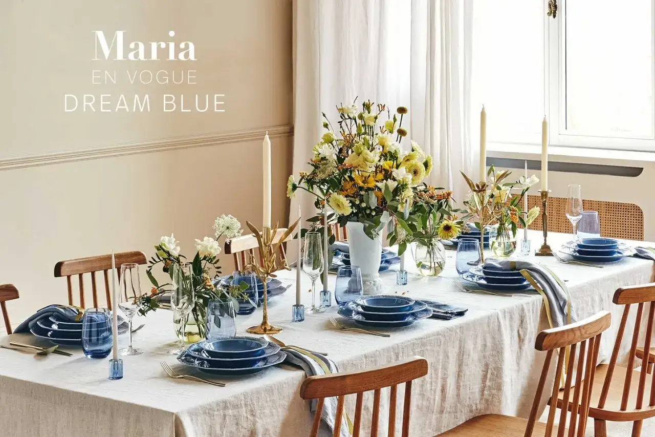 Väl dukat för en vett och etikett middag med blåa detaljer, blommor och ljus.