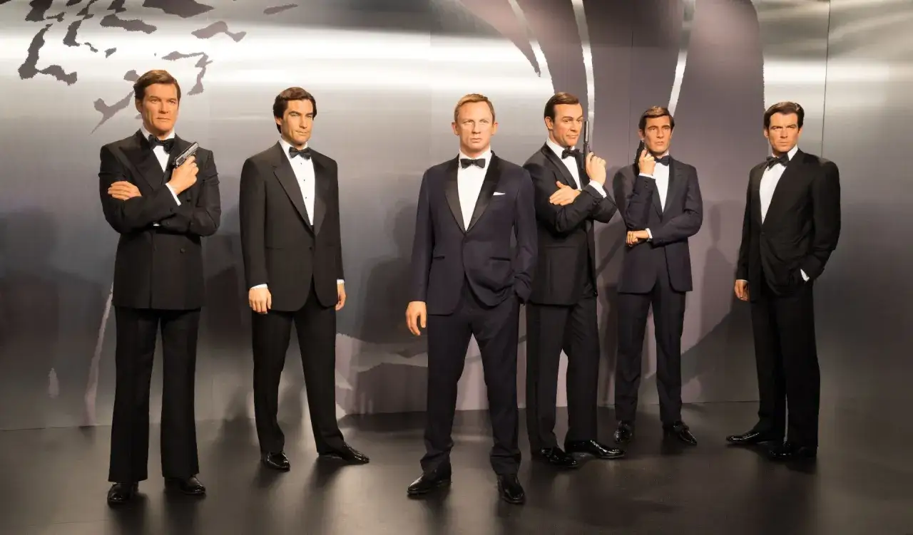 Vaxdockor av sex olika James Bond-skådespelare, alla klädda i smoking. En samling som representerar en era av nya James Bond-filmer.