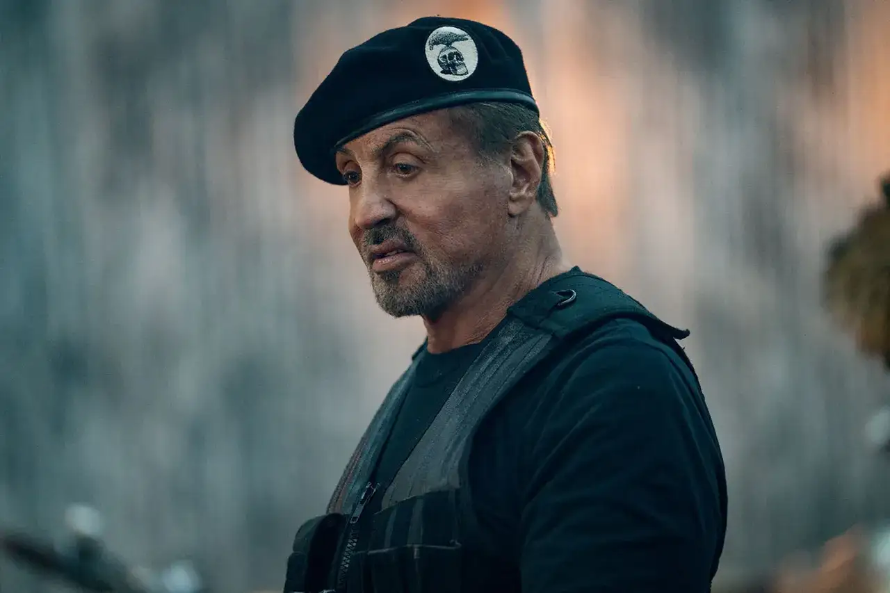 Sylvester Stallone bär en svart basker med en dödskalle-emblem, redo för action i en ny sylvester stallone serie.